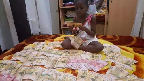 #UgandaDecides young girl counting Uganda shillings #UgandaDecides